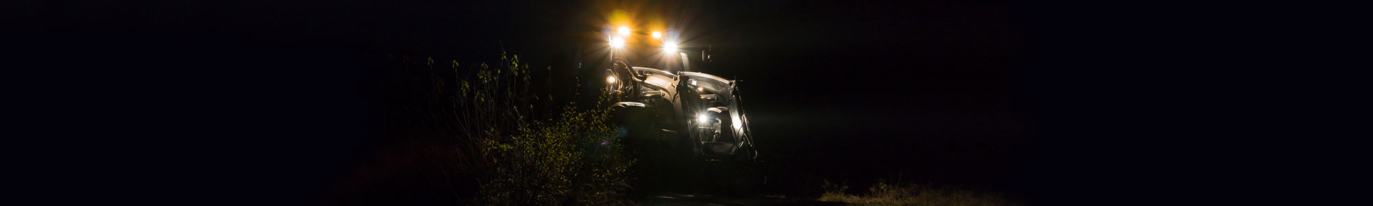 Traktor kjører i mørket med kraftige ekstralys