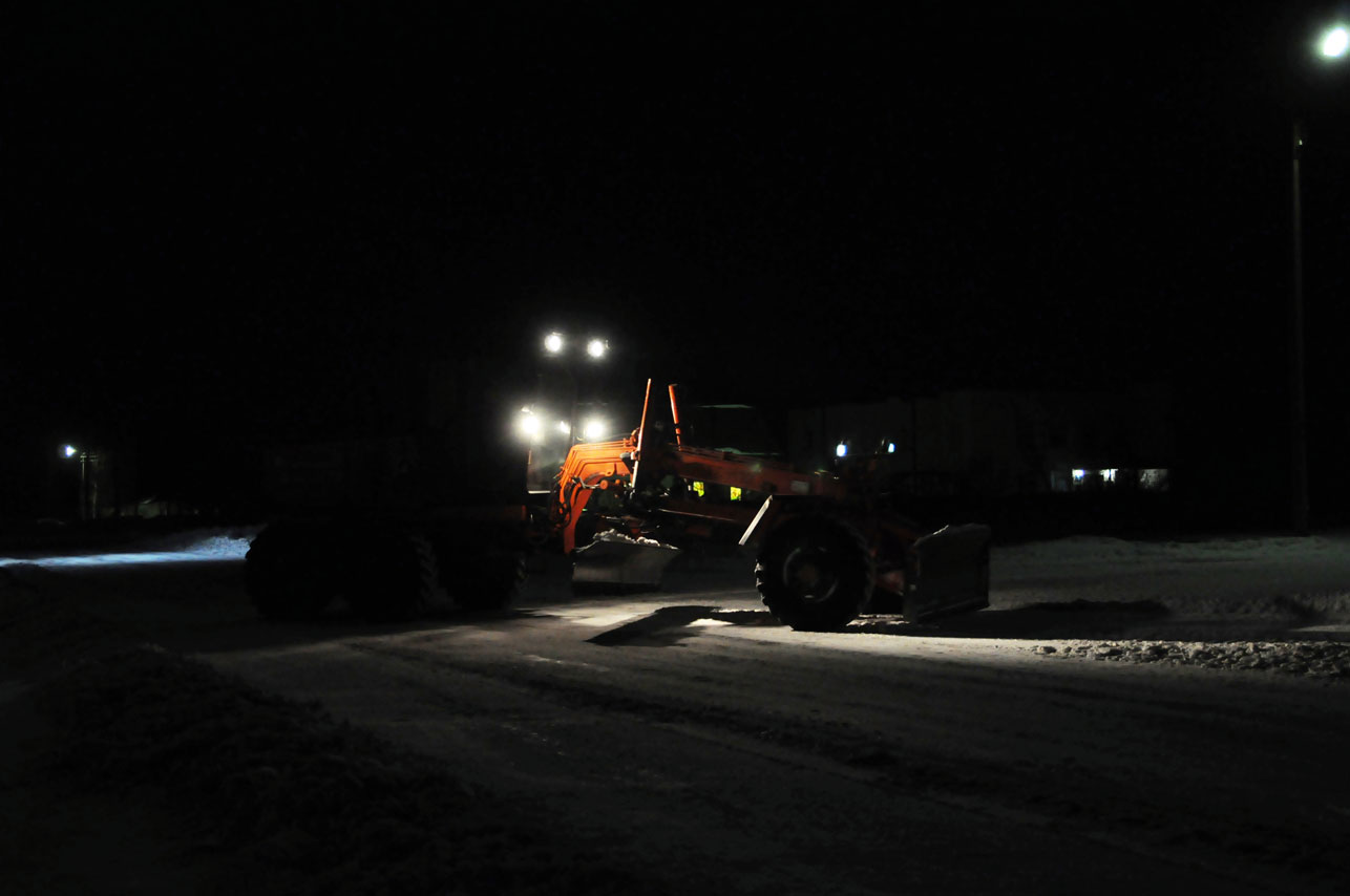 Traktor med kraftige arbeidslys som jobber i mørket