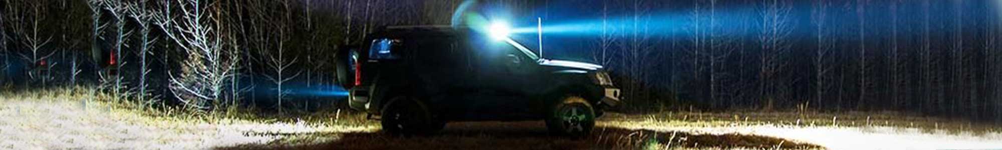 Bil med scenebelysning som lyser opp et stort område rundt bilen i mørket